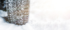 Winter tyre. Car tires on winter road covered with snow.